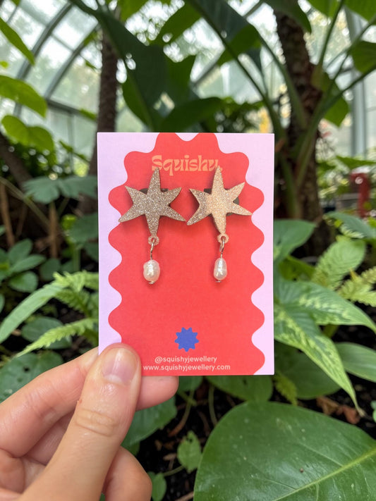 Abstract acrylic star earrings with real pearl drops inspired by modern art and museum gift shop jewellery.